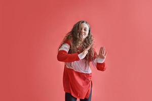 Joven mujer urbana bailando sobre fondo rojo, moderno estilo hip-hop delgado adolescente