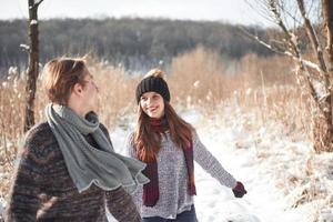 la pareja se divierte y se ríe. Beso. Pareja joven inconformista abrazándose en Winter Park. historia de amor de invierno, una hermosa joven pareja con estilo. concepto de moda de invierno con novio y novia foto