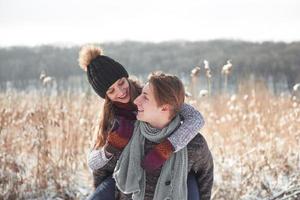 Happy couple playful together during winter holidays vacation outside in snow park photo