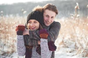 Happy young couple has fun on fresh snow at beautiful winter sunny day on vacation photo