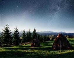 fantásticos montones de cielo estrellado y pueblos tradicionales de montaña. cárpatos, ucrania foto