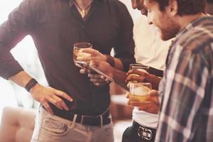 Whiskey. Group of friends guys with glasses of whiskey. Concept party, bachelor party barbershop. photo