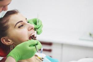 dentista curando a una paciente en la estomatología. concepto de prevención temprana e higiene bucal foto