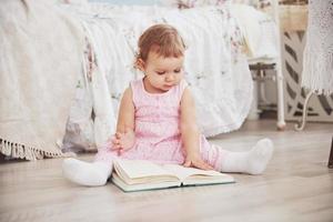 Beautiful little girl playing toys. Blue-eyed blonde. White chair. Children's room. Happy small girl portrait. Childhood concept photo