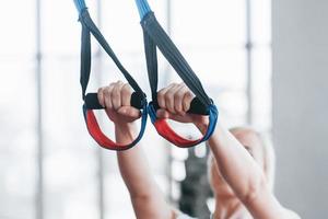 Mujeres haciendo flexiones de brazos entrenando con trx correas de fitness en el gimnasio concepto entrenamiento estilo de vida saludable deporte foto