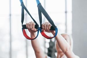 Women doing push ups training arms with trx fitness straps in the gym Concept workout healthy lifestyle sport photo