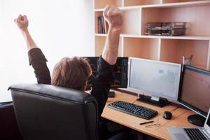 Young stock trader broker stretching hands at workplace, he first achieved great success on the stock market photo