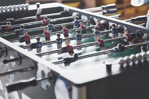 futbolín en el centro de entretenimiento. Imagen cercana de jugadores de plástico en un partido de fútbol. foto