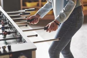 Table football in the entertainment center. Beautiful girl playing football photo