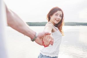 A smiling happy woman with a playful expression and a hand with her husband. photo