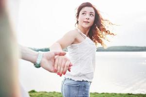 A smiling happy woman with a playful expression and a hand with her husband. photo