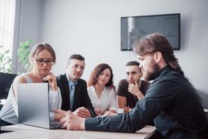 Colleagues communicate with work questions in modern office space photo