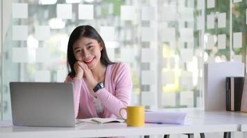 una joven estudiante con una computadora portátil y un café, está trabajando en un proyecto para graduarse. foto