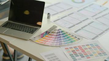 Laptops with color charts and equipment on the desk for the UX team to design apps in a modern office. photo