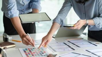 The UX design team with tablet plans to develop a prototype smartphone application. photo