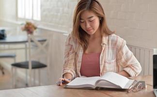 Primer plano de una chica universitaria leyendo un examen final en la sala de estar de casa. foto