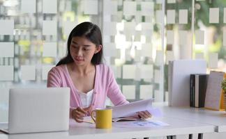 Female student are using laptop to search for information online. photo