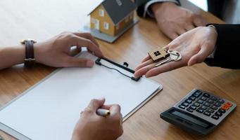 firmar un contrato de compraventa de casa entre el comprador y el vendedor y entregar la llave de la casa. foto