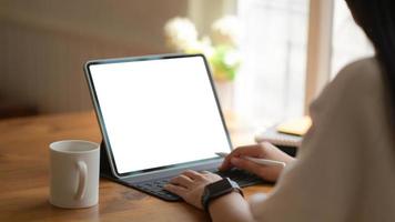 Las mujeres de negocios jóvenes están utilizando un portátil de pantalla en blanco con una taza de café en la oficina moderna. foto