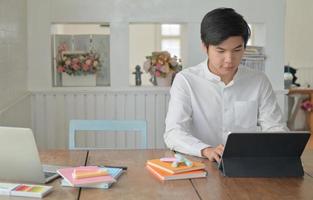 los estudiantes varones están usando una computadora portátil para estudiar el verano en línea en casa. foto