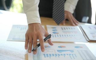 The management is checking the company earnings chart on the office desk. photo