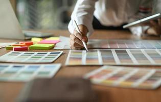 The architect is comparing the color chart and using the tablet. photo