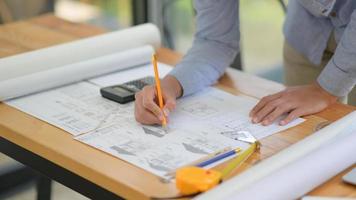 The architect is designing the construction. He drafts the floor plan to present to the client. photo