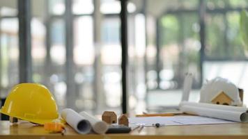 Safety hats and floor plans with drawing tools placed on the desk in the office of the architect. photo