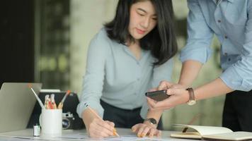A team of professional designers are working with smartphone and laptops to design applications. photo