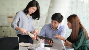 Cropped shot of young designer team working on smartphone application project with using digital tablet in modern office room. photo
