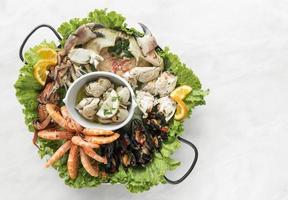 Plato gourmet de mariscos frescos mixtos en la mesa del restaurante español foto
