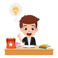 Happy cute kid boy character siting study desk studying with books and bag with idea symbol vector