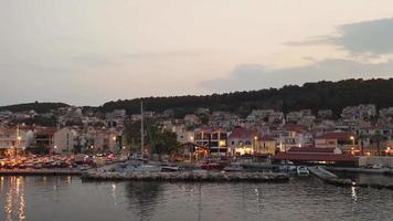 Argostoli, Hauptstadt auf der Insel Kefalonia, Griechenland, Europa. Video von der Fähre zur blauen Stunde mit eingeschalteten Lichtern der Stadt aufgenommen.