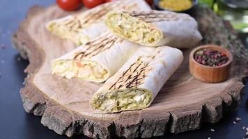 Delicioso shawarma fresco con carne y verduras sobre una mesa de hormigón oscuro video