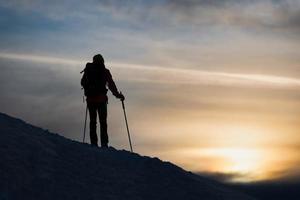 A mountaineer skier watches the sun go down photo