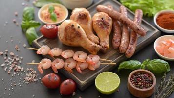 Composition of sausages, chicken, pork and shrimp prepared on grill, as well as vegetables prepared on grill video