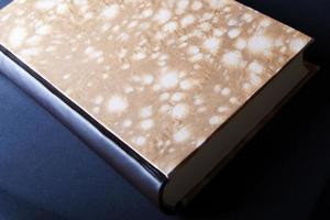 Art of Book binding. Handmade book with marble paper front and leather book spine seen from above