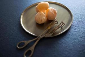 Delicious cheese appetizer and antique serving tongs on a bronze platter. photo