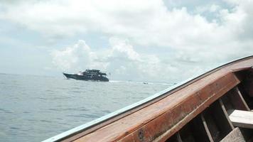 La vista desde el barco de madera vio el tráfico oceánico congestionado para transportar turistas a la isla de Phi Phi. Ambos transbordadores, lanchas rápidas de pasajeros en el negocio de viajes marítimos crean salpicaduras de agua blanca en el mar de Andaman. video