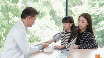 une mère amène sa fille malade à un rendez-vous d'examen avec un médecin asiatique au service de pédiatrie d'une clinique pour enfants. traiter les maladies et consulter sur la santé de la famille.