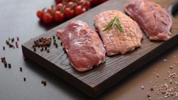 Raw duck breast with herbs and spices on a dark concrete background video