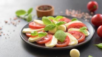salada caprese italiana com tomate fatiado, queijo mussarela, manjericão, azeite de oliva