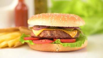 hamburger di manzo artigianale e patatine fritte su sfondo nero video