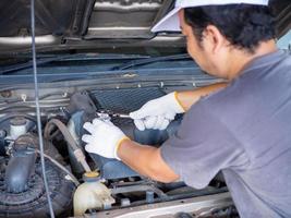 Mechanic holding a block wrench handle while fixing a car. photo