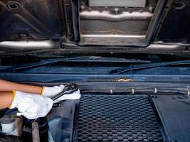 Mechanic holding a block wrench handle while fixing a car. photo