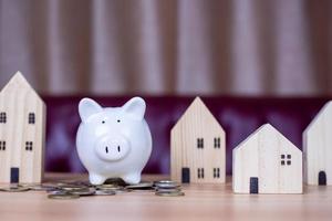 A white piggy bank is placed on a pile of coins photo