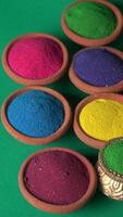 Diwali Festival showing Colourful rangoli in bowls,clay lamp or diya on background photo