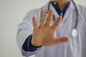 El doctor levantó la mano para detenerse en casa para evitar la propagación de la infección. concepto social a distancia. foto