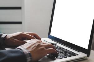 hand typing on laptop keyboard and mock up screen blank computer.Blank screen space for advertising media photo