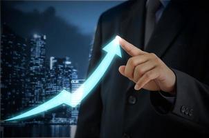 businessman touching an arrow on a virtual screen. Investment business and economic concept photo